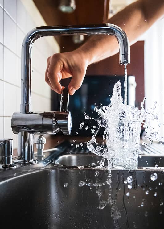 imagem de uma torneira e um copo de água